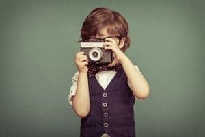 Boy in nice clothes taking picture with camera