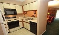 A fully furnished kitchen in a Gatlinburg condo with a refrigerator, oven, sink, microwave, and more. 