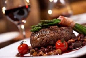steak dinner with wine in background